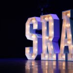 Large illuminated SRA letters on stage
